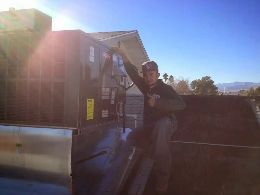HVAC technician performing Boiler Repair on a rooftop unit in Erie